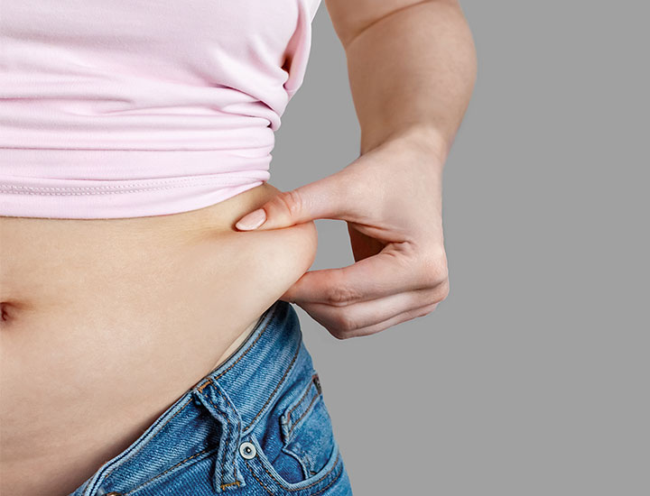 Woman pinching stomach fat