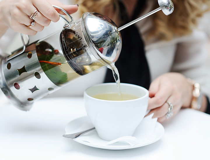 Woman pouring a pot of tea