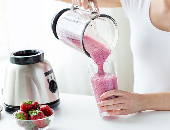 Woman pouring a smoothie from a blender