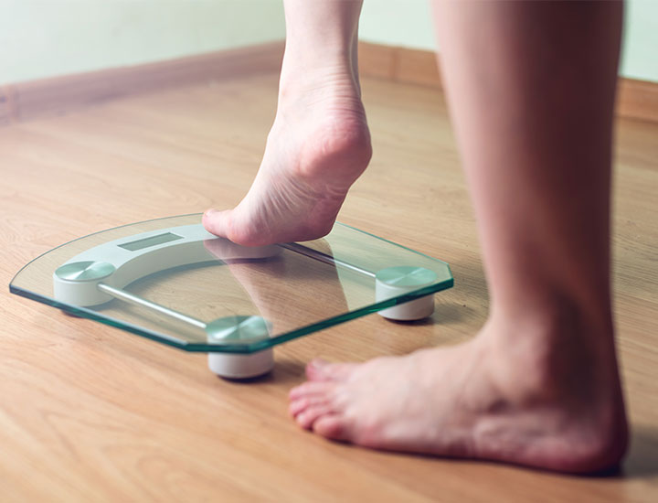 Woman stepping on a scale