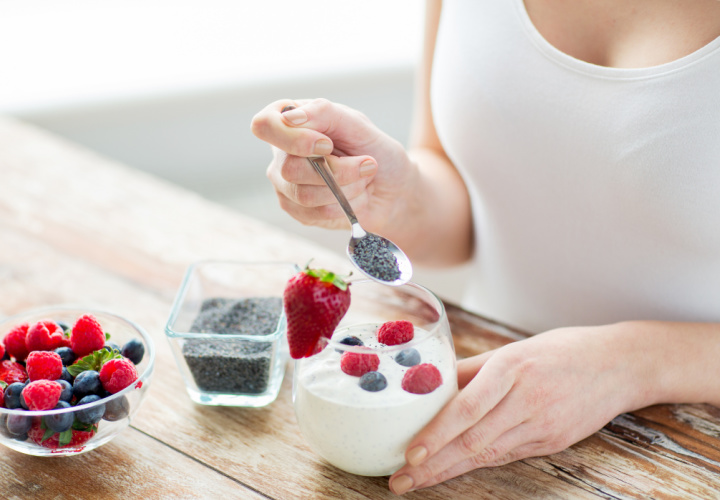 Woman putting chia seeds on parfait