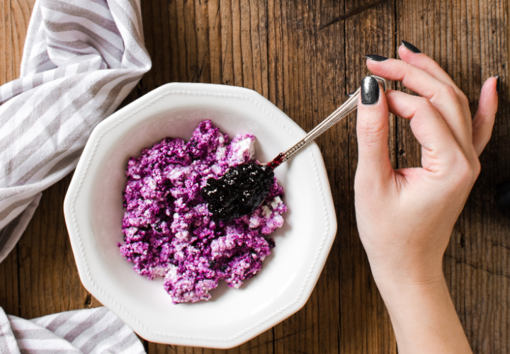 Woman eating a bowl of cottage cheese and berries