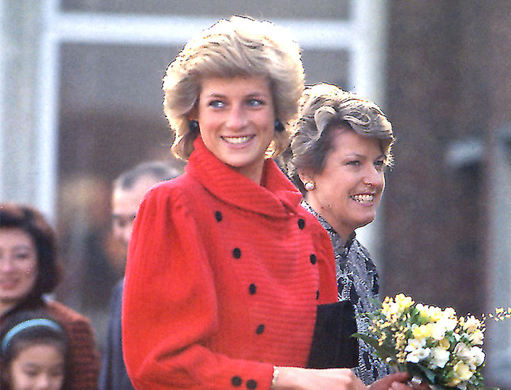 Princess Diana in a red coat holding flowers