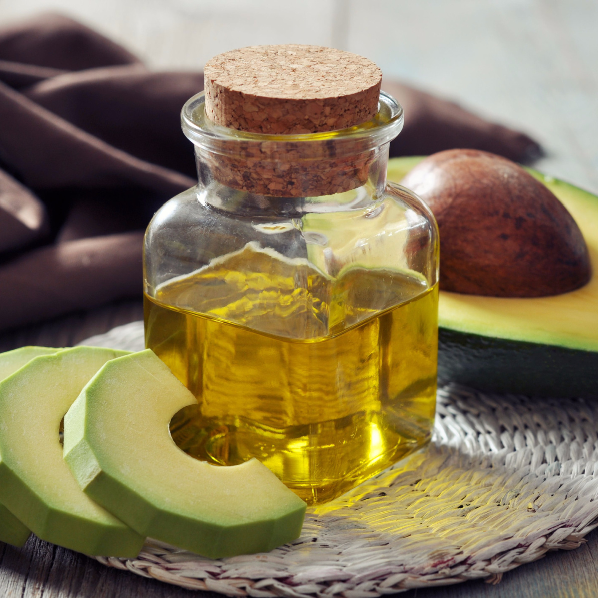 jar of avocado oil isolated cutting board sliced avocados