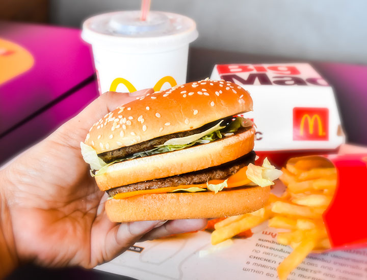 Hand holding a McDonald's Double Cheeseburger