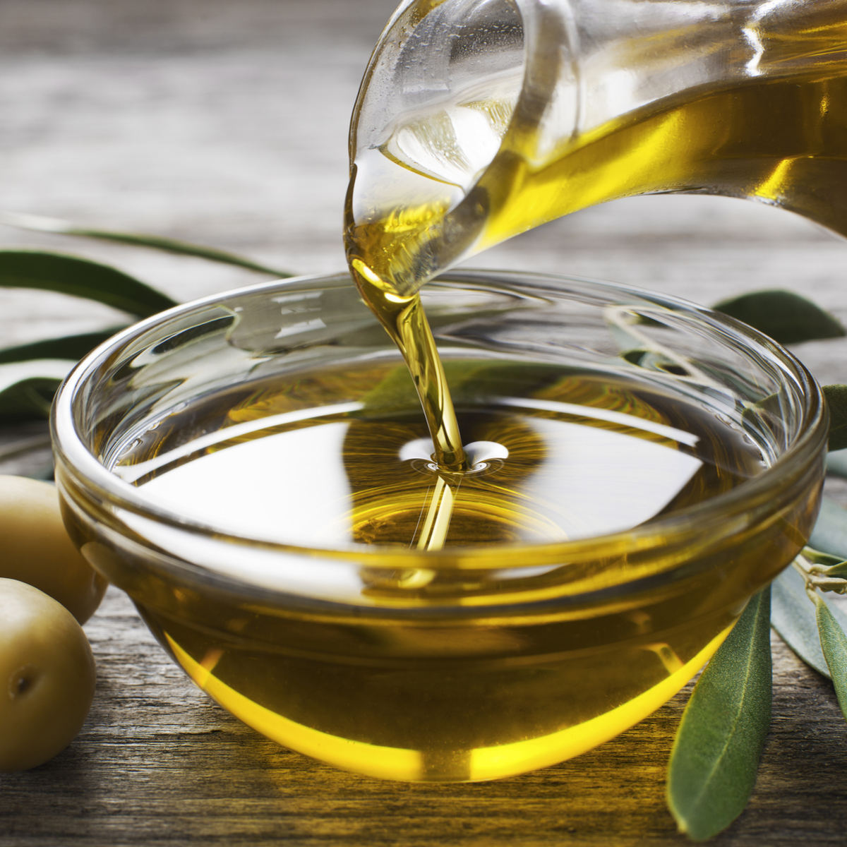 olive oil pouring into glass bowl