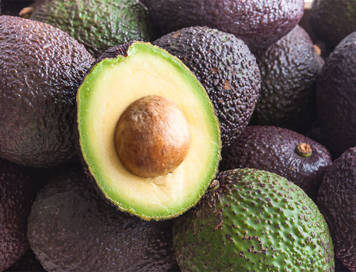 piles of whole and cut avocado