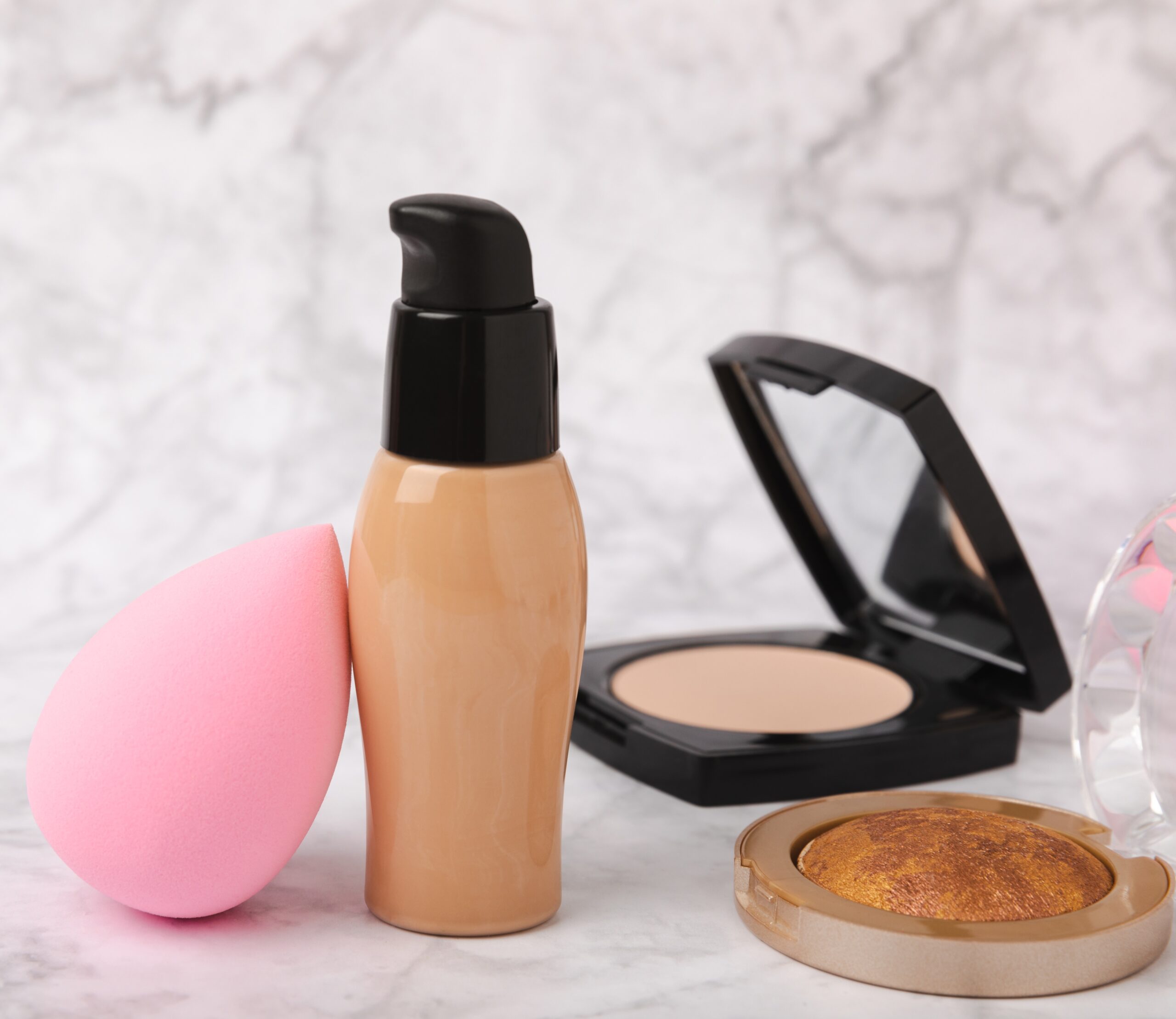 various makeup products liquid foundation beauty blender compact powder display