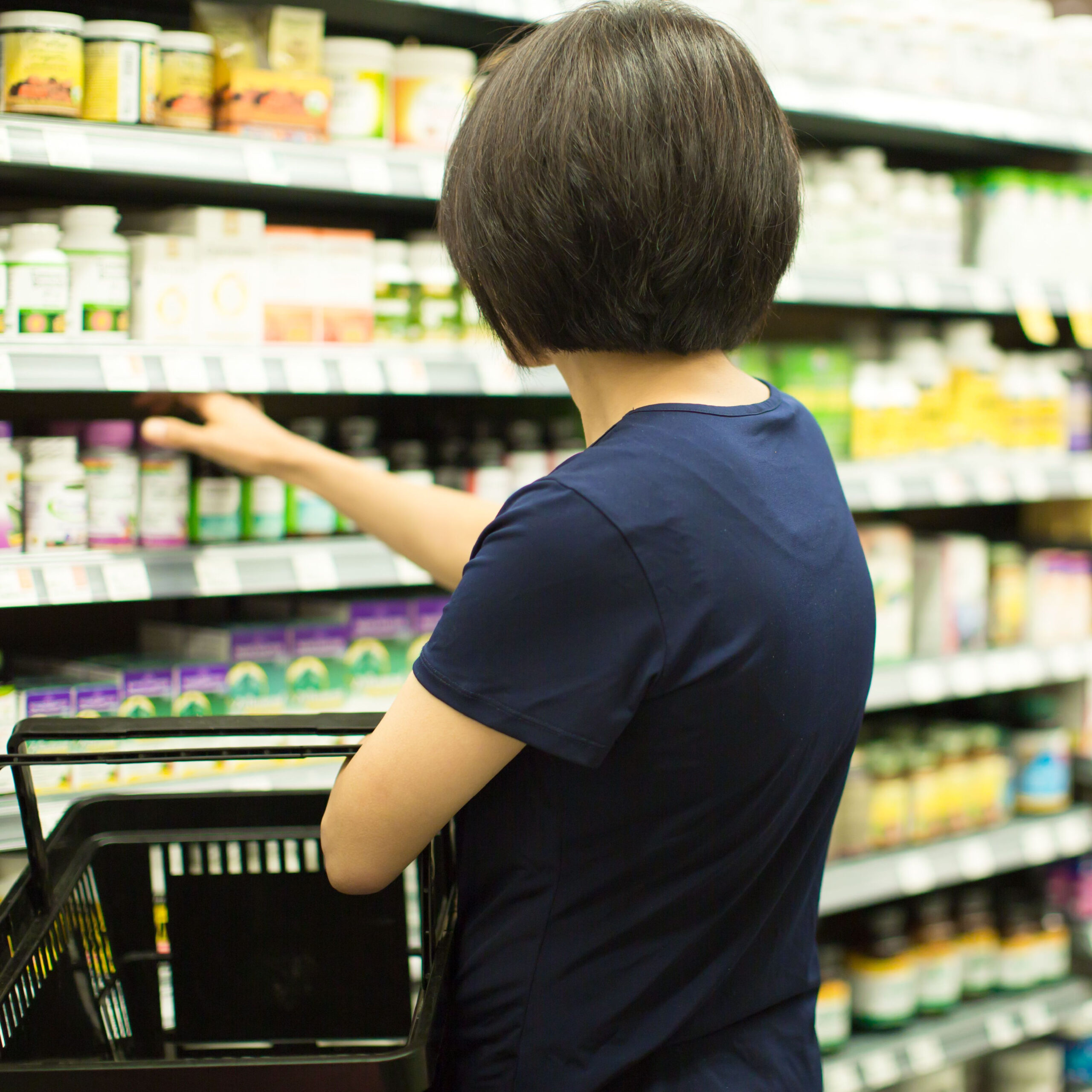 woman browsing supplement aisle at store