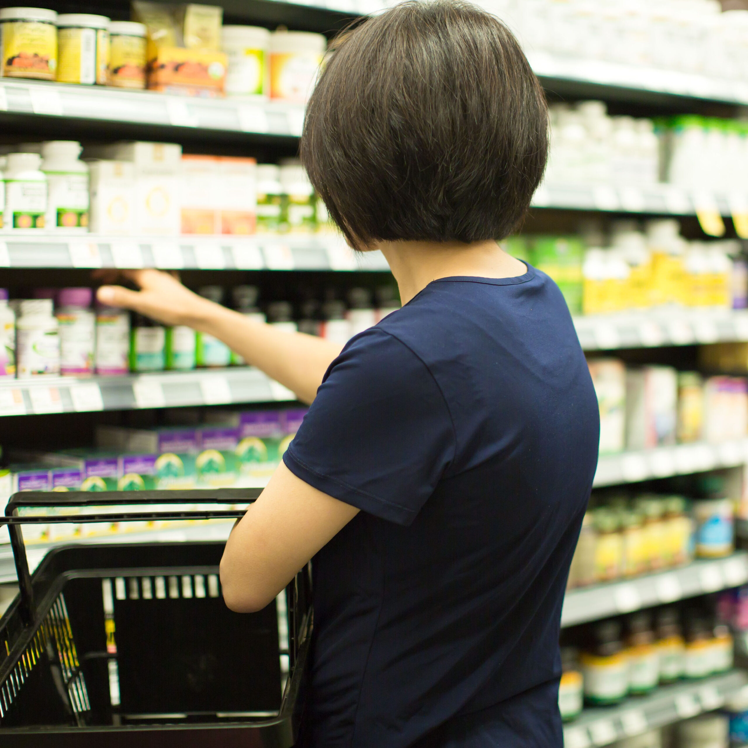 woman browsing supplement aisle in store
