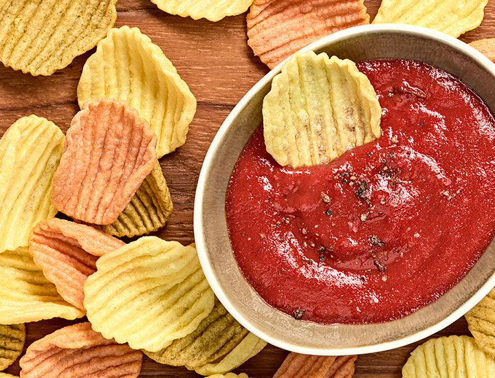 Veggie chip dipped into salsa