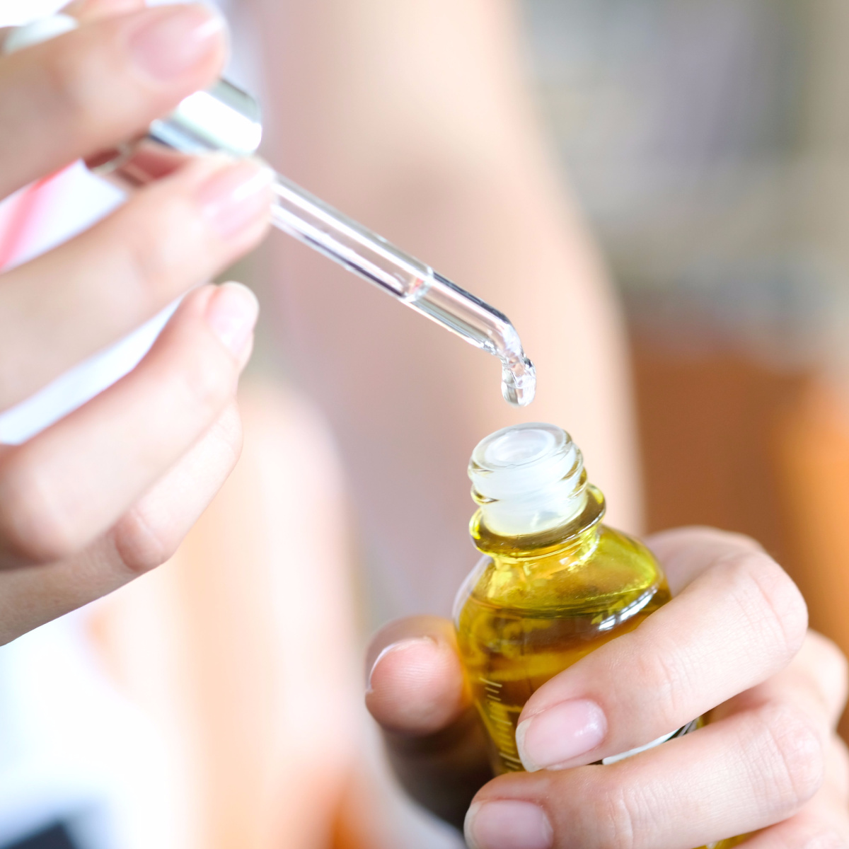 hands holding vitamin c serum open jar dropper