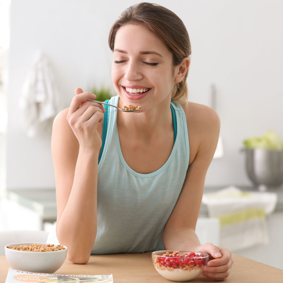 woman healthy skin eating pomegranate seeds bowl kitchen