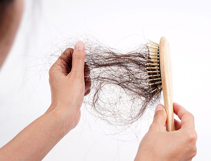 woman-pulling-hair-out-of-brush