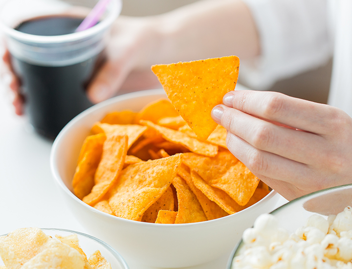 Woman snacking on chips and soda