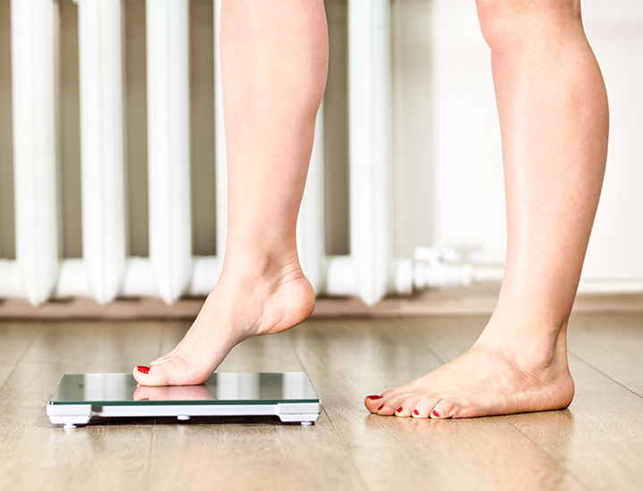 Woman stepping on a scale