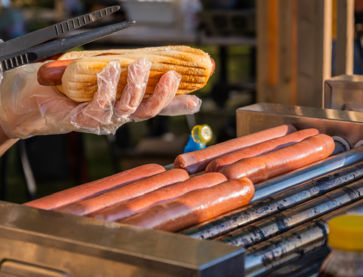 Person cooking hot dogs