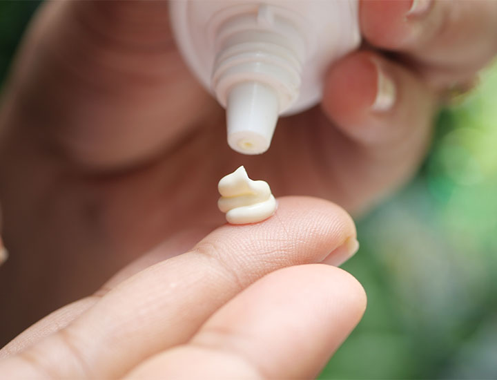 dollop of facial sunscreen on fingers squeezed from tube