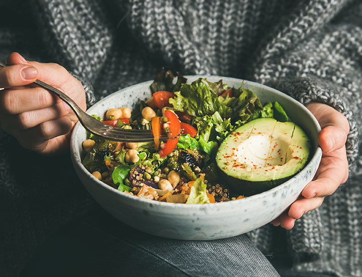 girl sitting with a bowl of whole foods