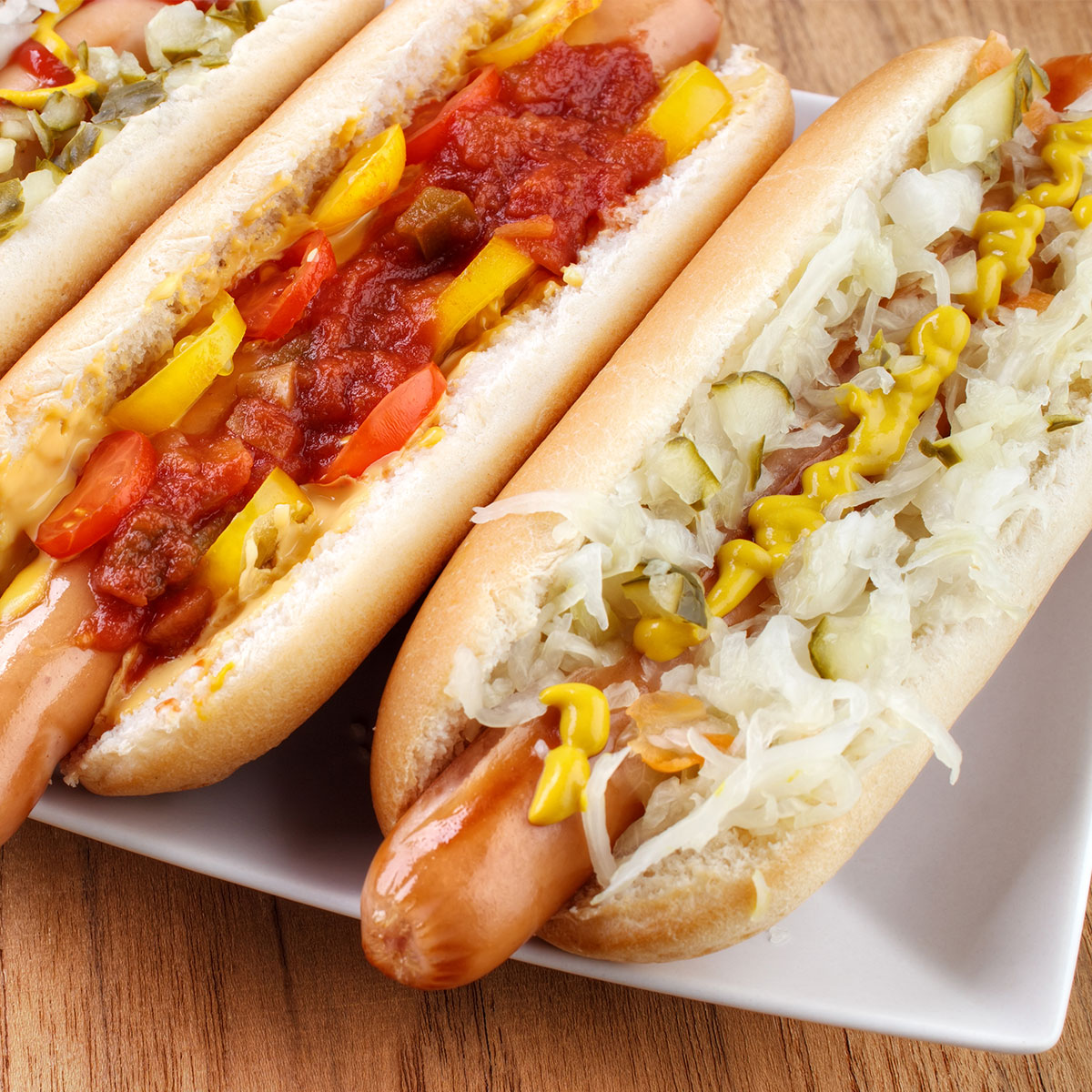 hot dogs topped with sauerkraut, ketchup, mustard, and other condiments