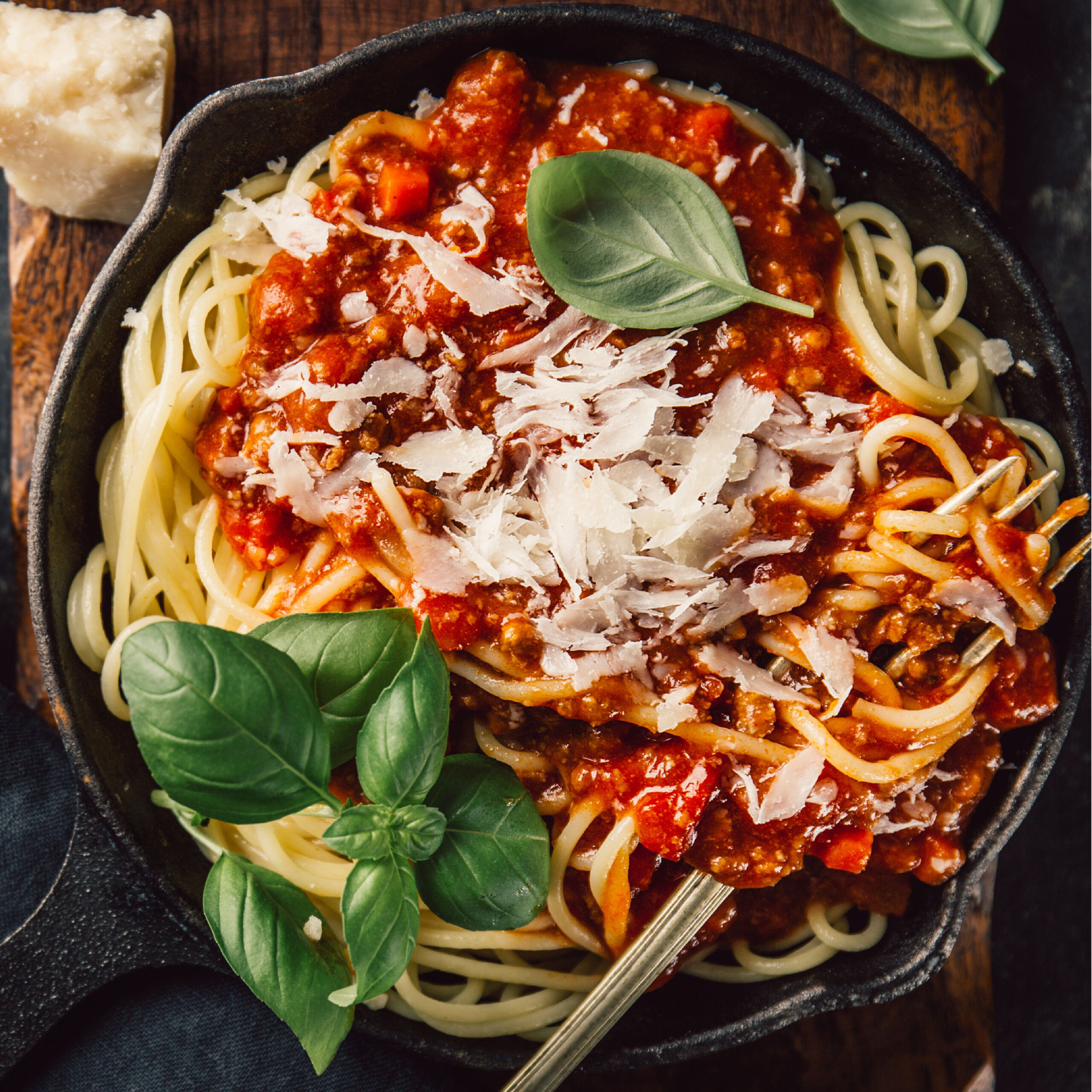 spaghetti topped with marinara sauce, cheese, and basil