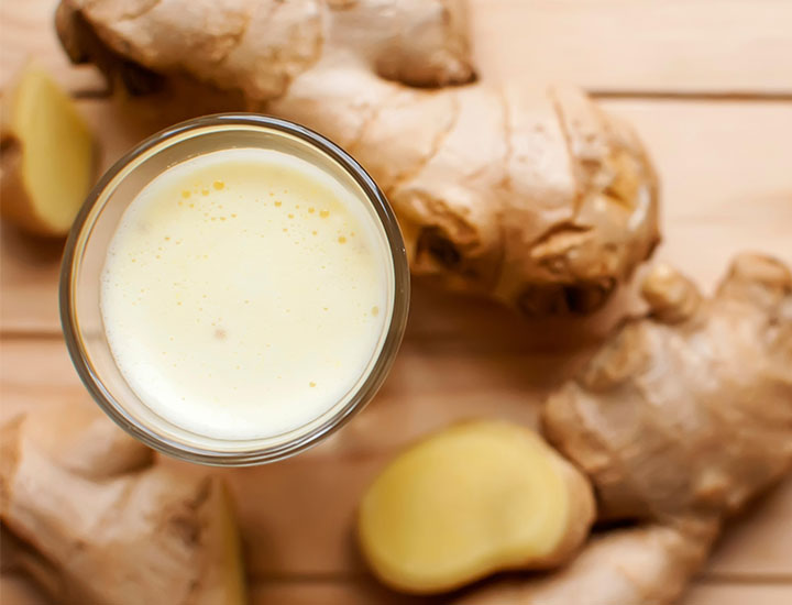 pale yellow smoothie with sliced ginger background