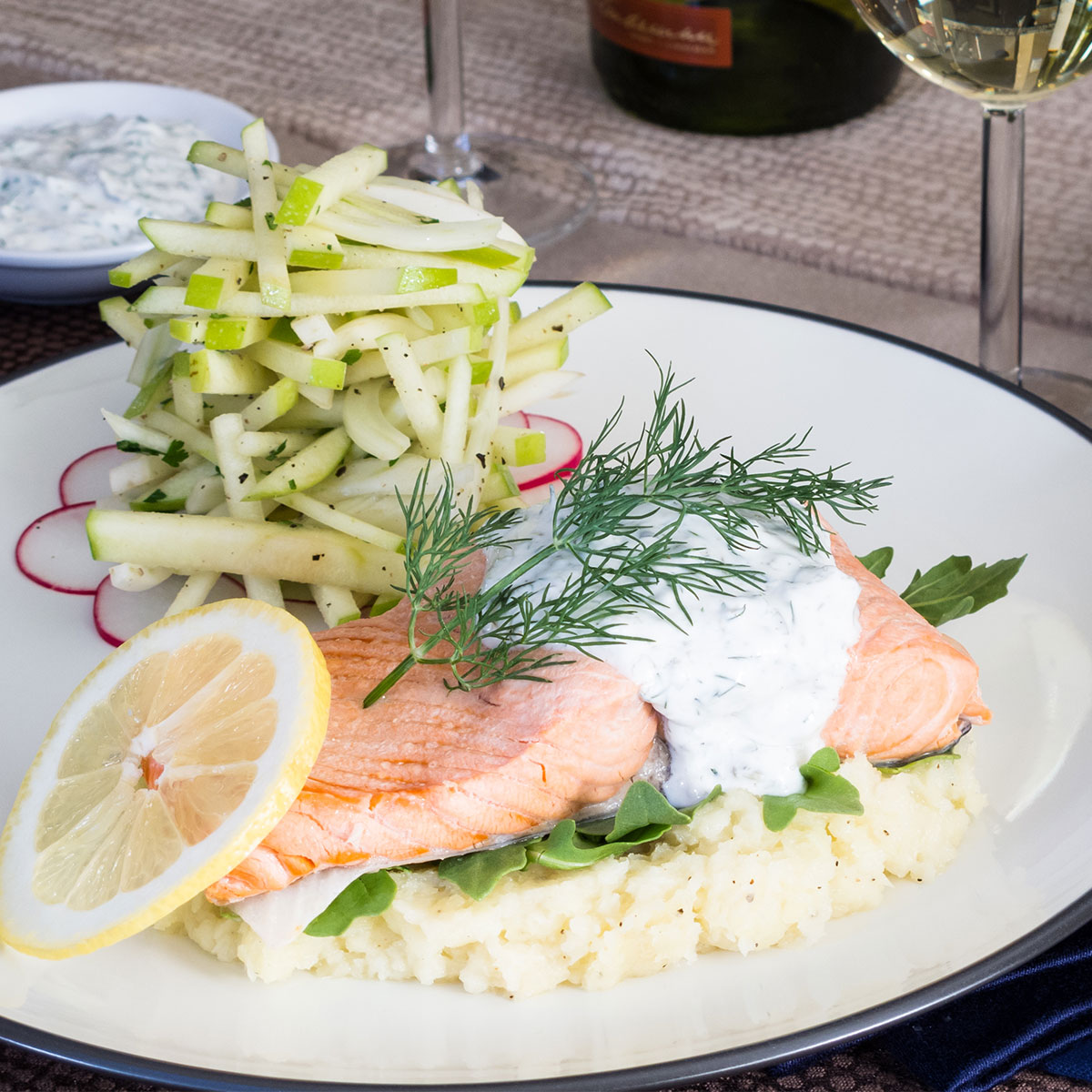 salmon on plate with green apple salad