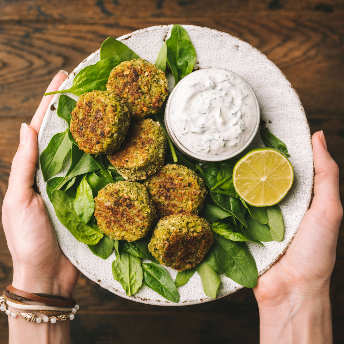 healthy falafel yogurt greens plate hands holding