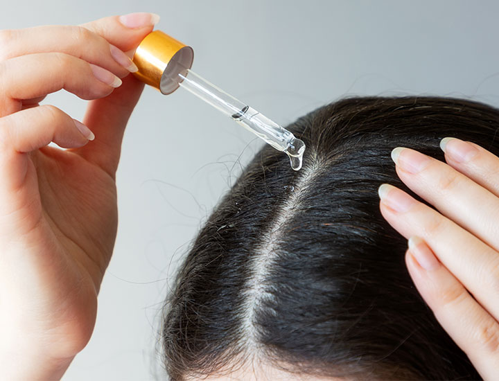 woman-applying-oil-to-hair