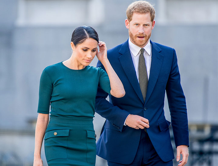 Meghan Markle Prince Harry looking disappointed wearing blue