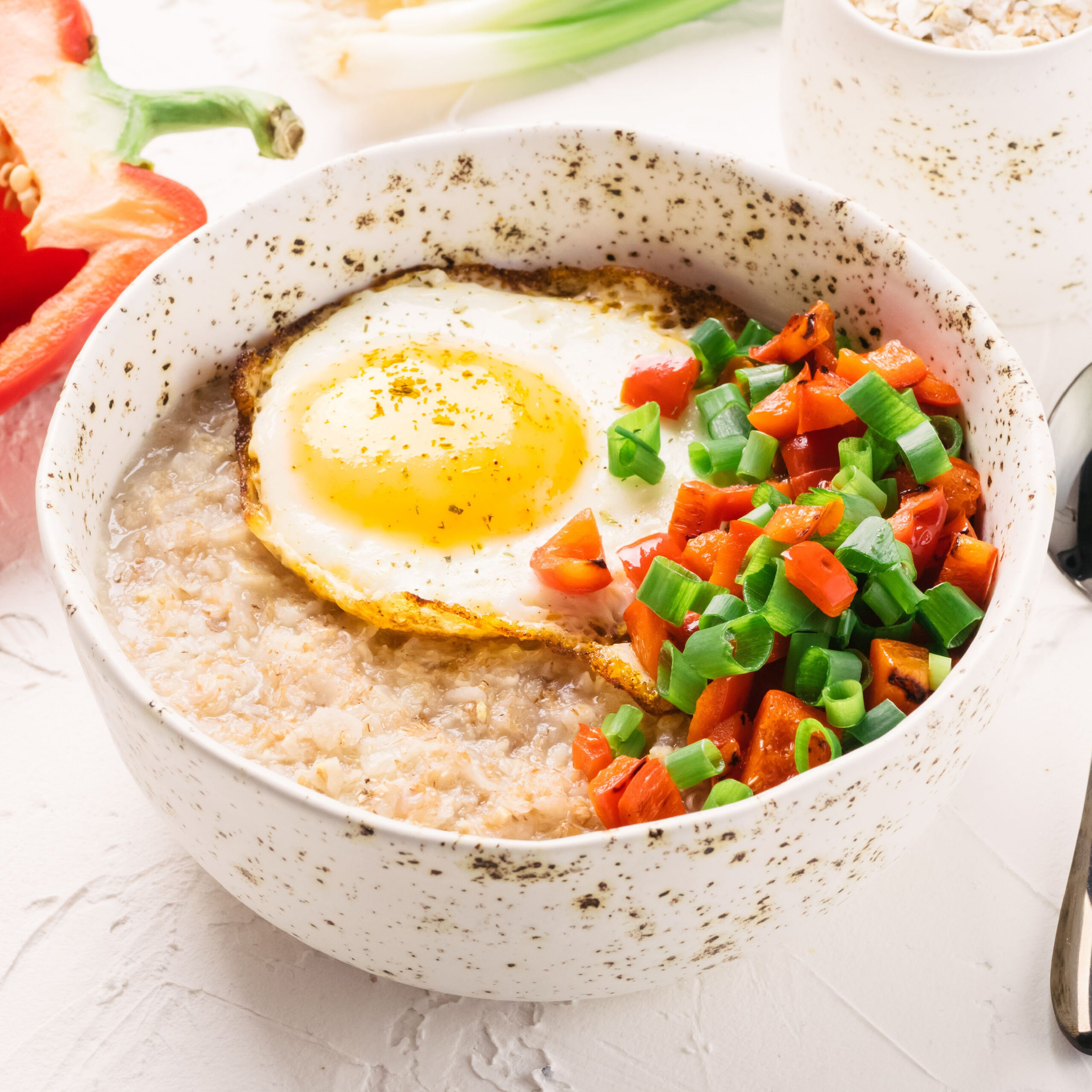 savory oatmeal topped with veggies and egg