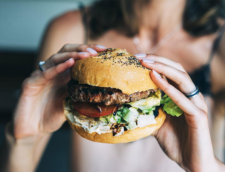 Woman about to eat a hamburger