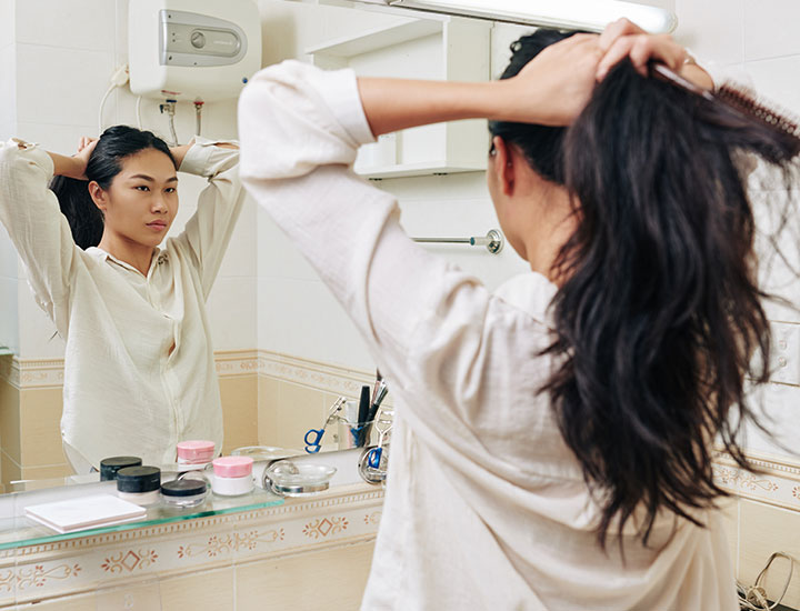 woman-styling-hair-ponytail