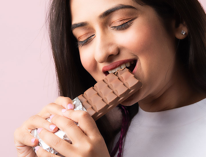 Woman eating a chocolate bar