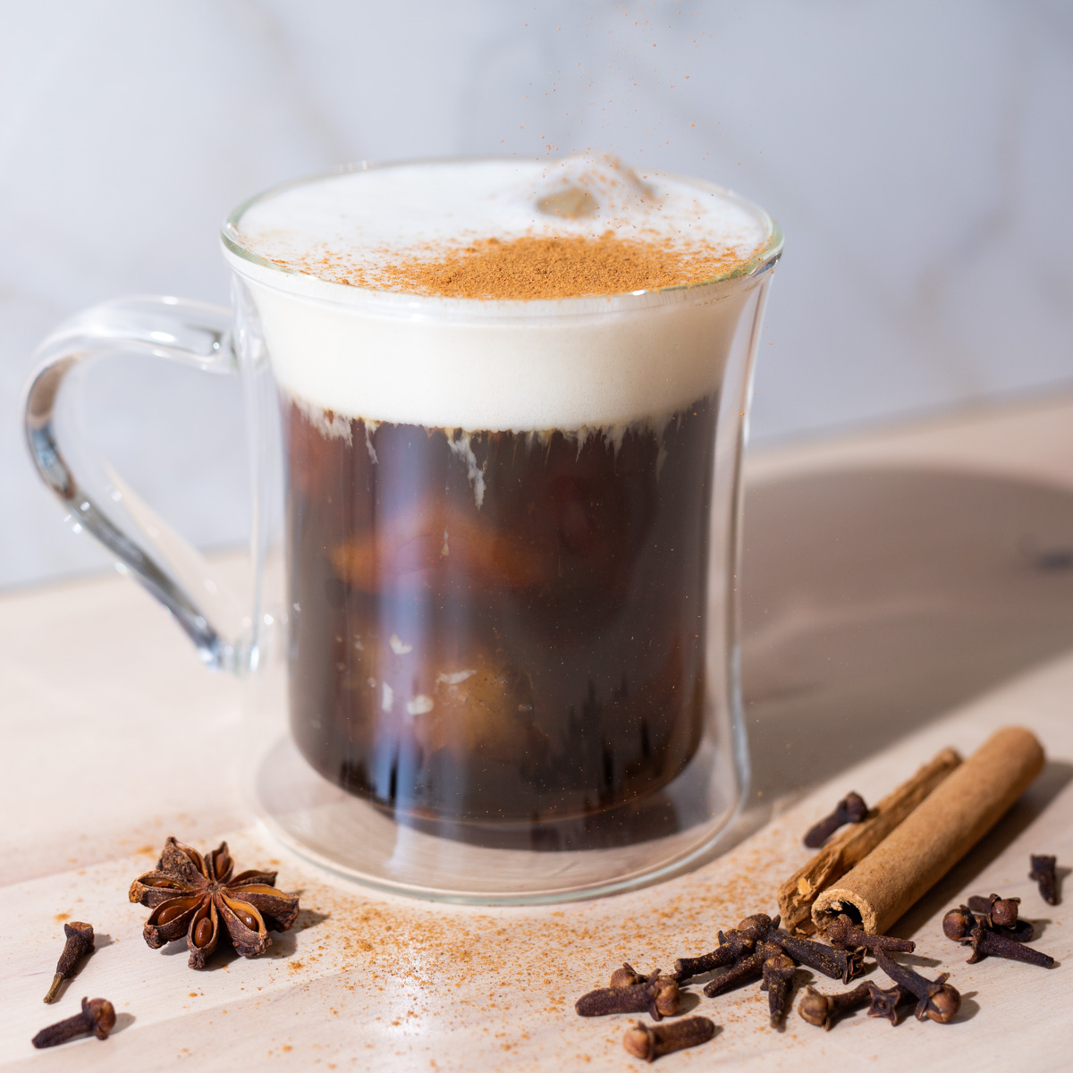 iced coffee topped with foam and spices