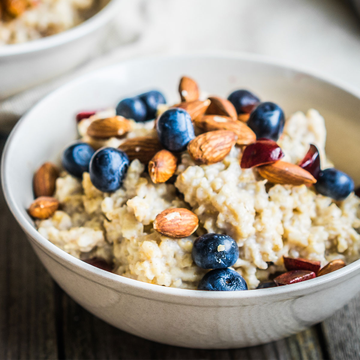 bowl of oatmeal topped with almonds and blueberries