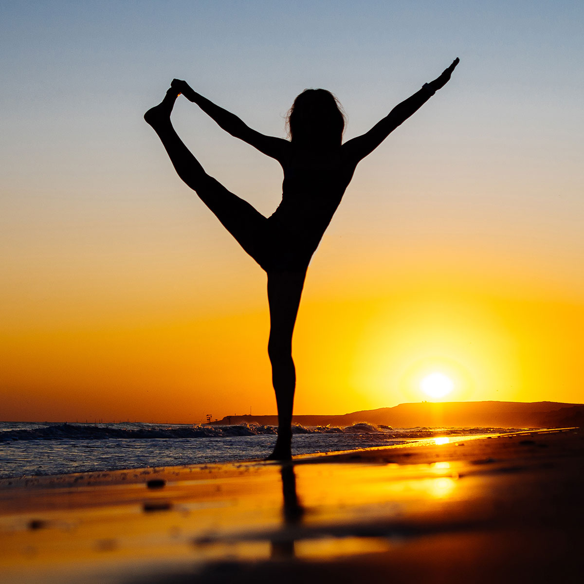 woman doing yoga pose on beach