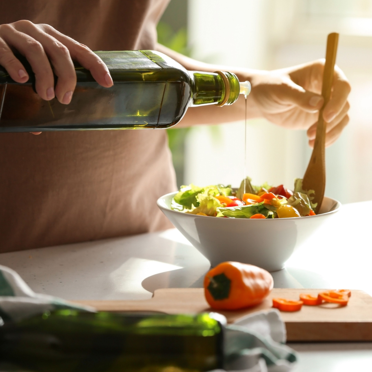 woman drizzling olive oil