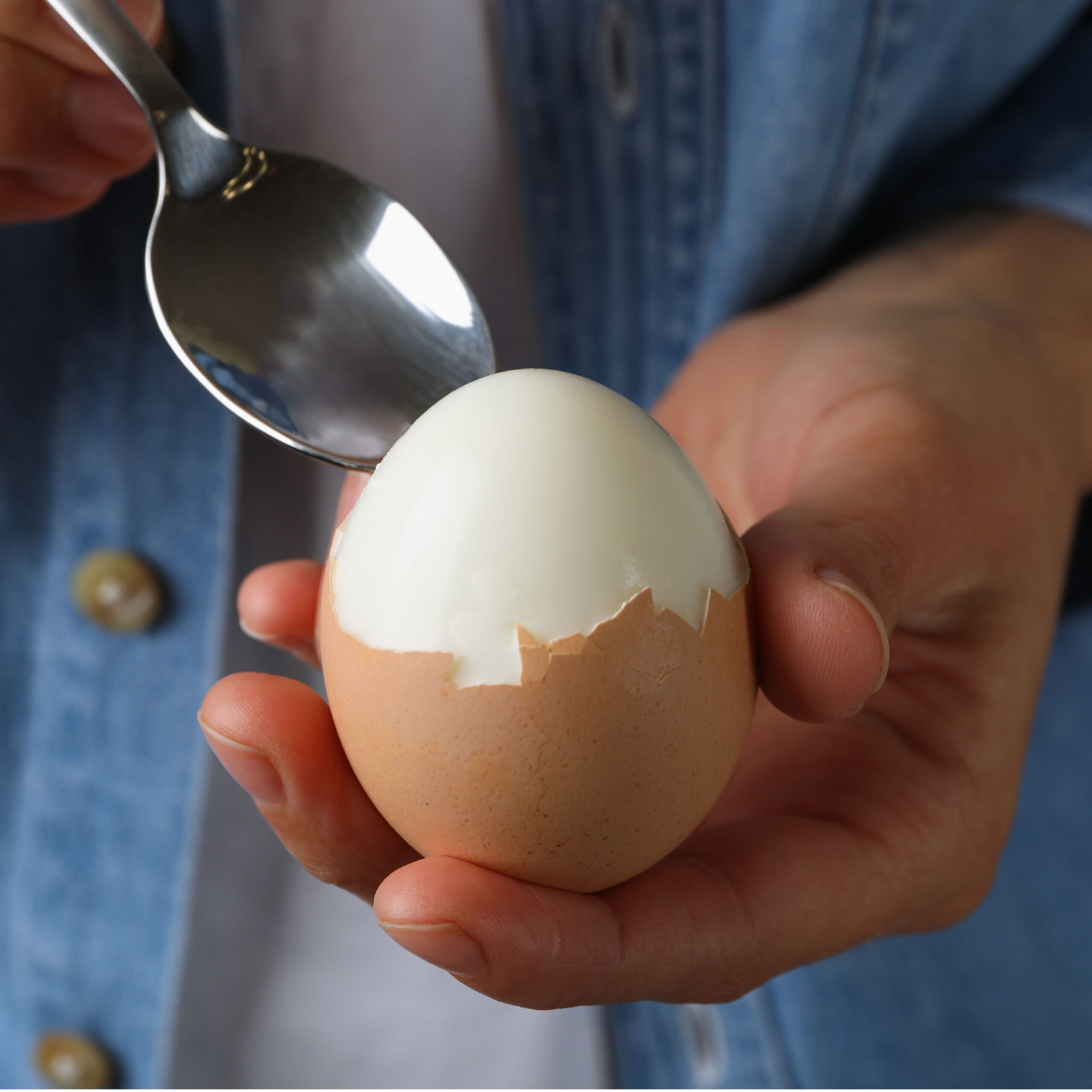 person breaking into hardboiled egg