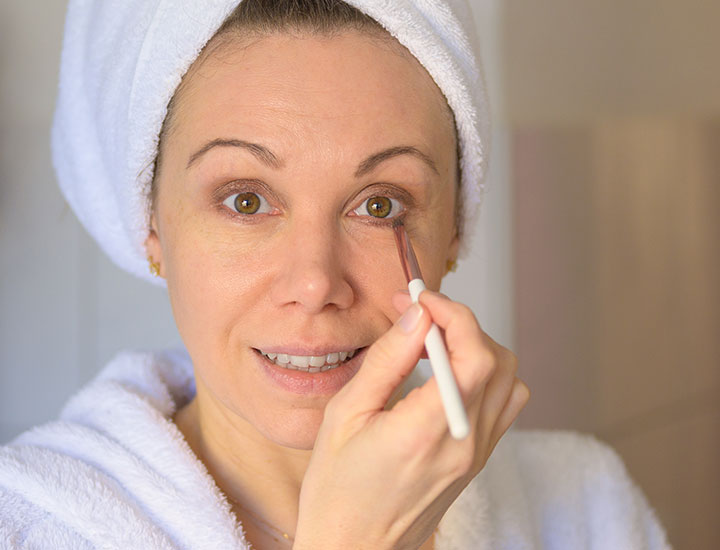 woman-applying-brown-eye-makeup