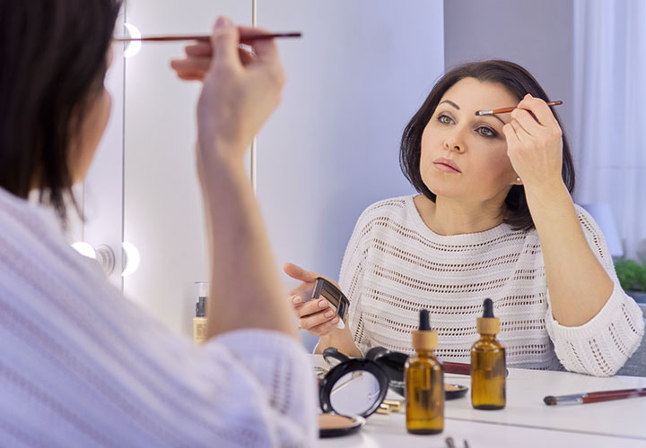 woman-applying-makeup-vanity