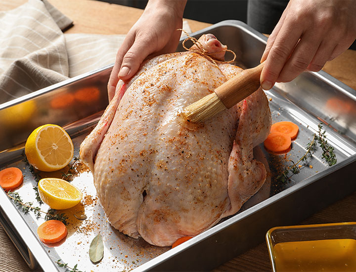 woman preparing turkey with spices