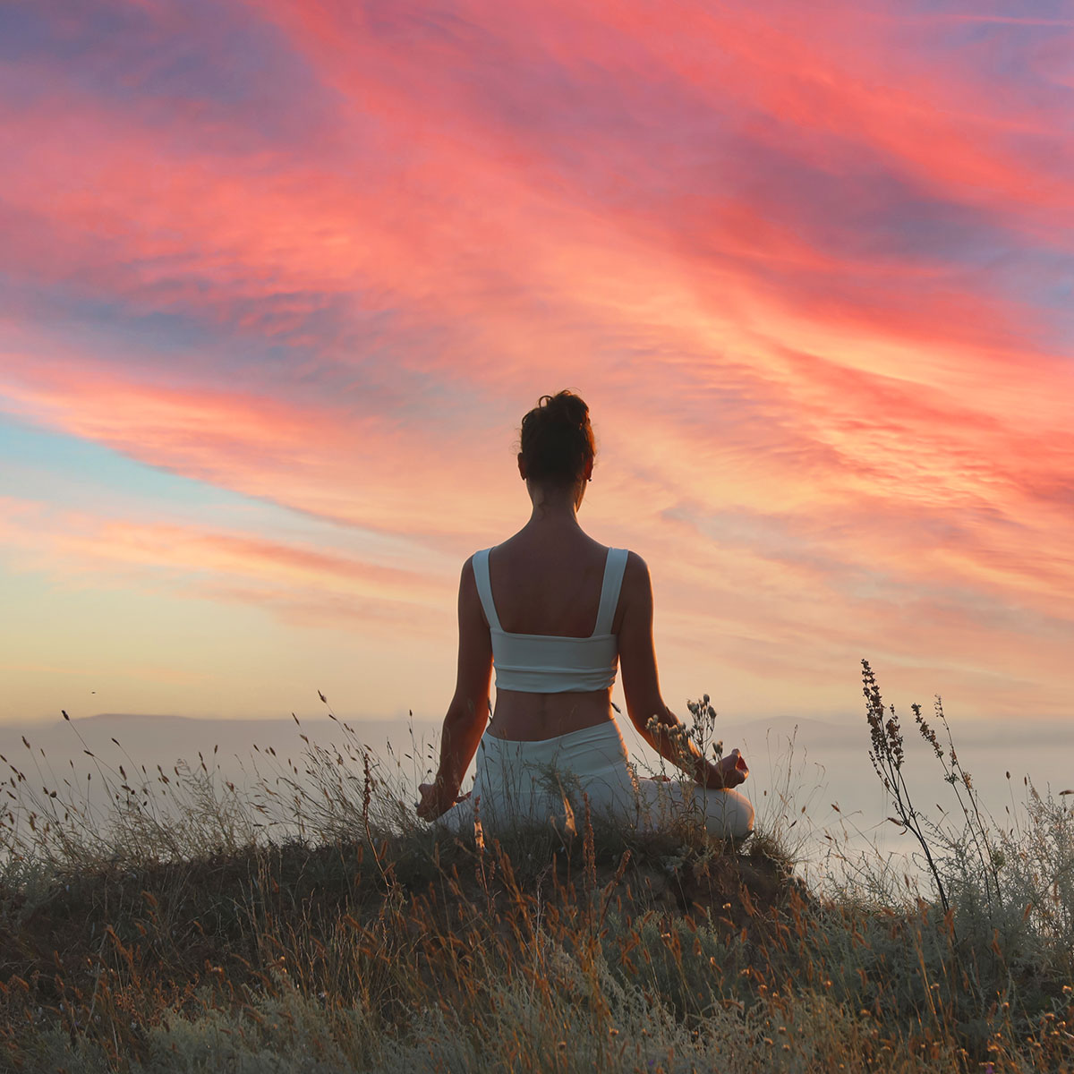 woman meditating on hill