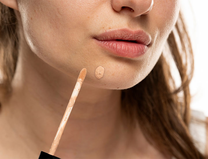 woman-putting-on-concealer