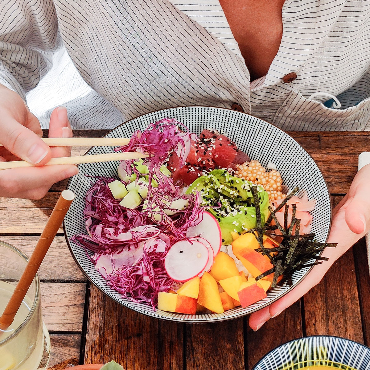 woman eating poke bowl