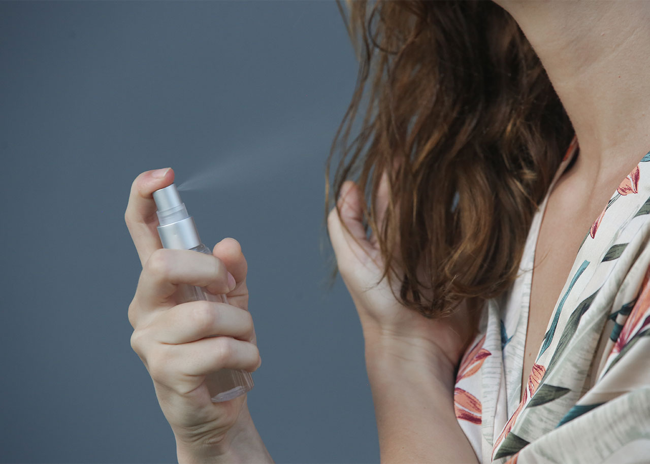 woman-spraying-product-hair