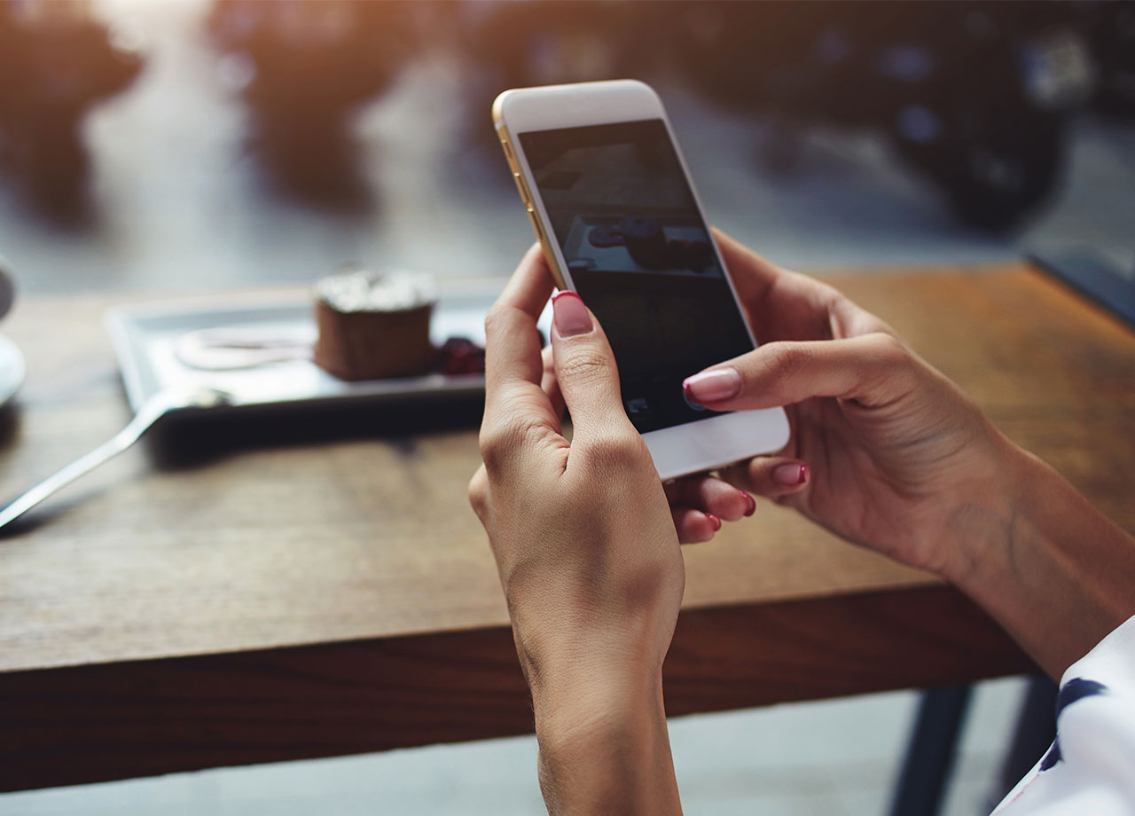 woman-using-iphone-cafe