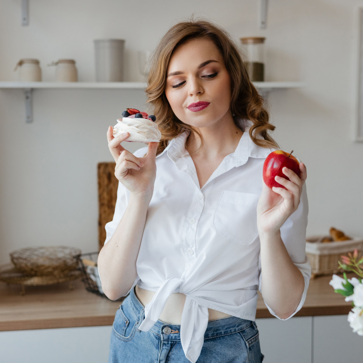 woman holding an apple and a dessert