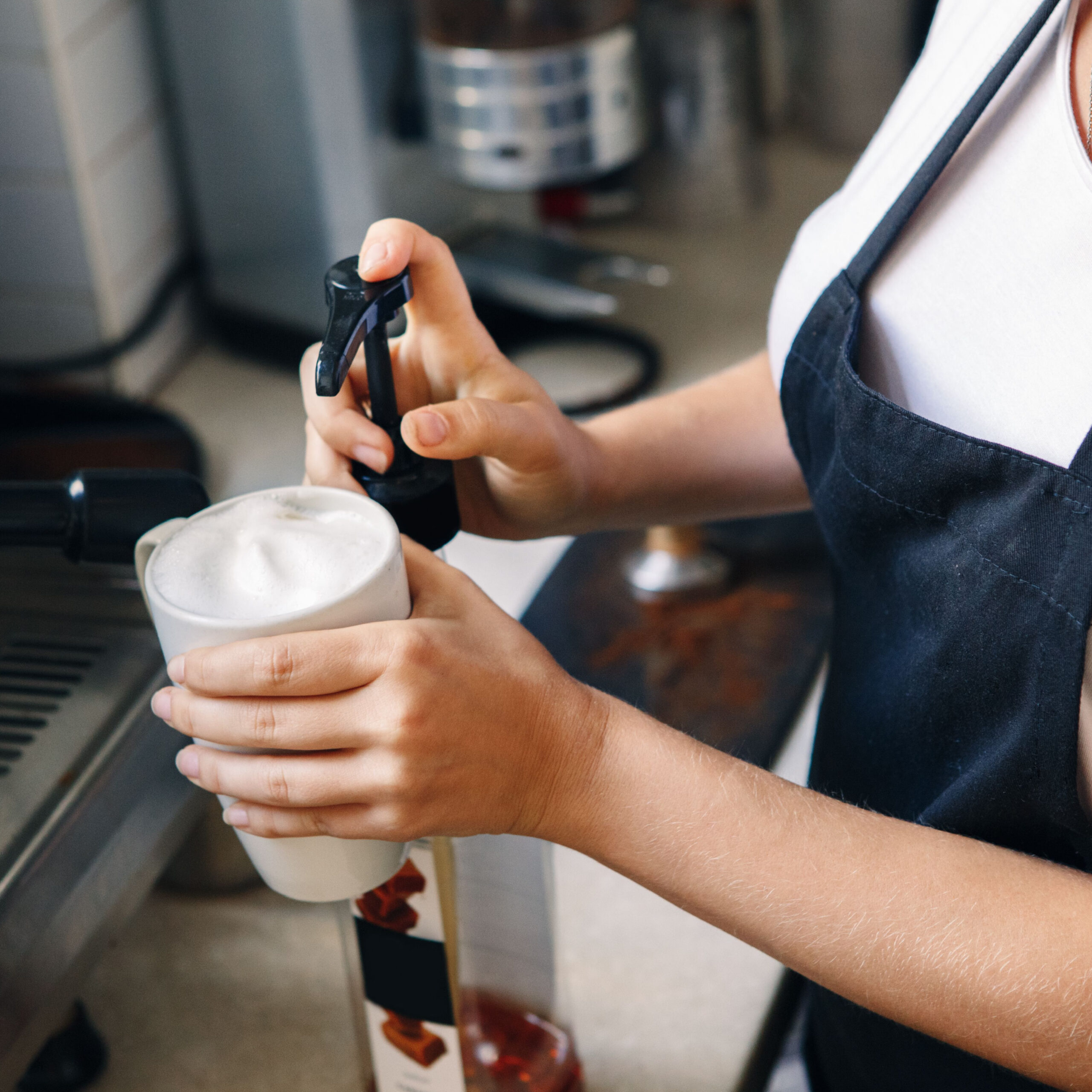 person adding syrup to coffee