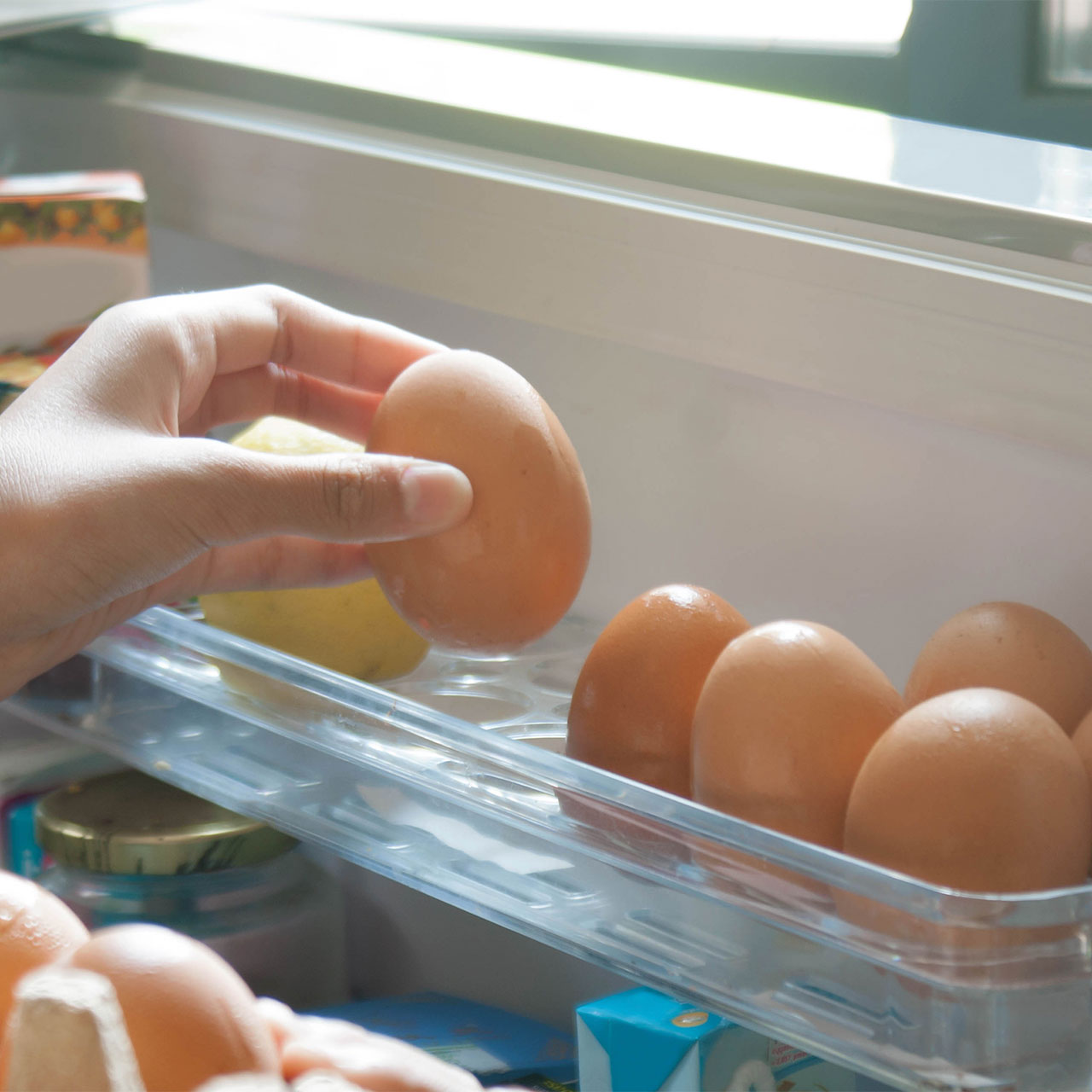 woman picking eggs from fridge